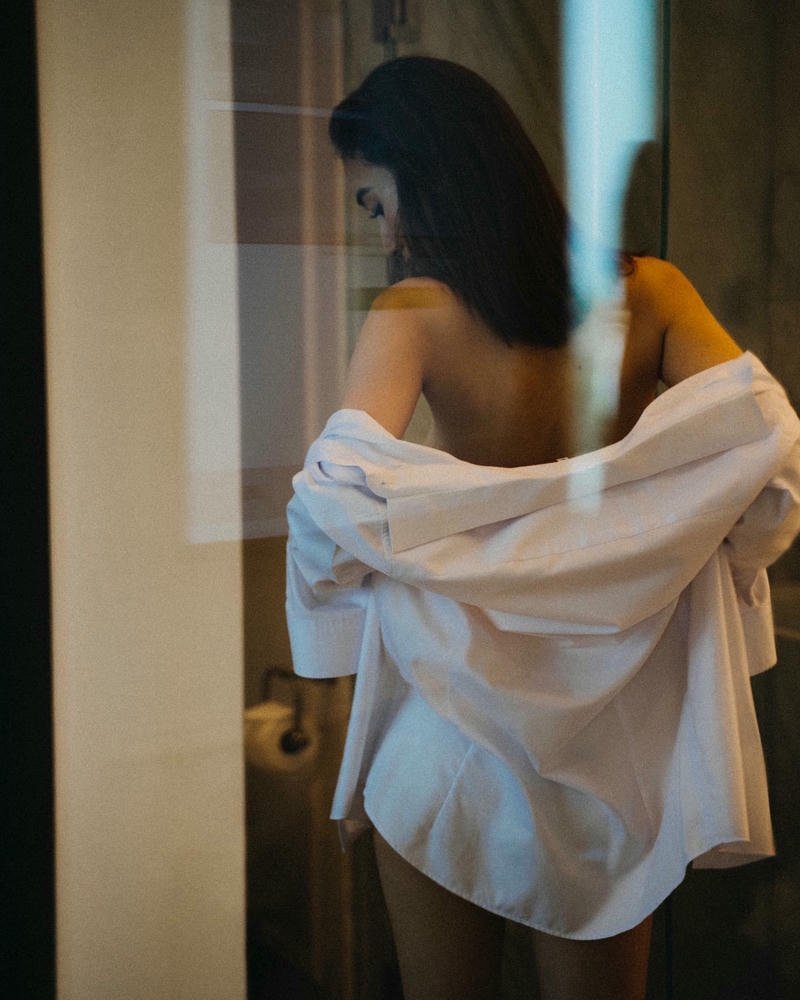 Ảnh Hà Thu Bikini trắng khoác áo sơ mi đứng trước gương soi