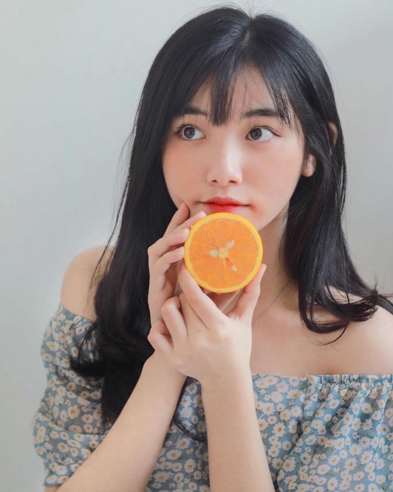 Ảnh Quỳnh Trương Tiktok cầm quả cam che nửa mặt dễ thương