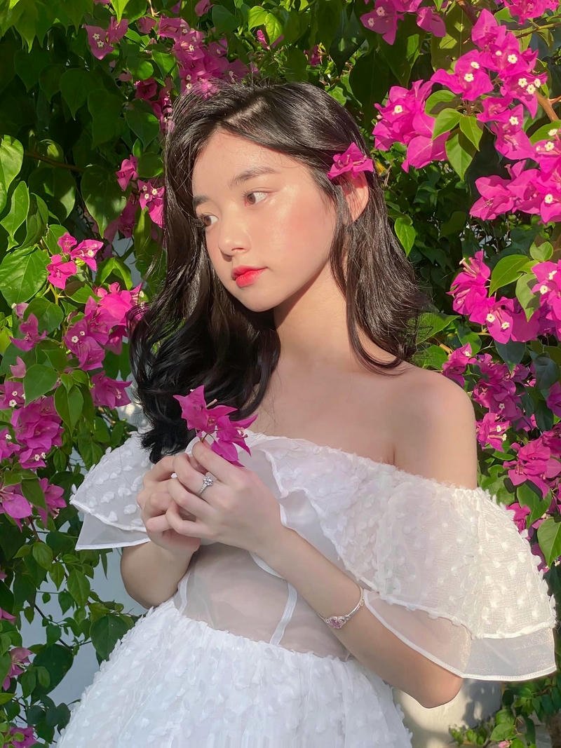 Ảnh Quỳnh Trương Tiktok mặc áo trễ vai bên hoa giấy