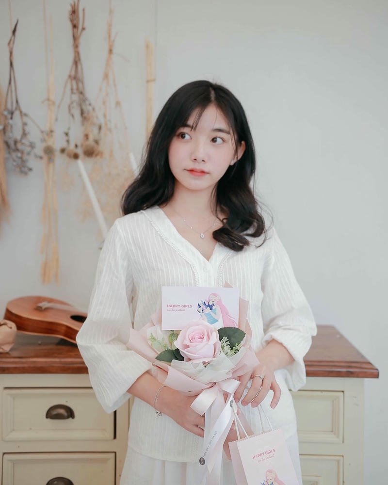 Ảnh Quỳnh Trương Tiktok mặc váy trắng cầm bó hoa đẹp