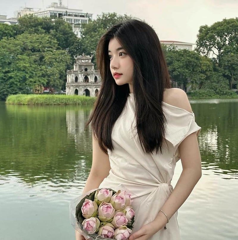 Ảnh Quỳnh Trương Tiktok mặc váy trắng đứng bên hồ nước