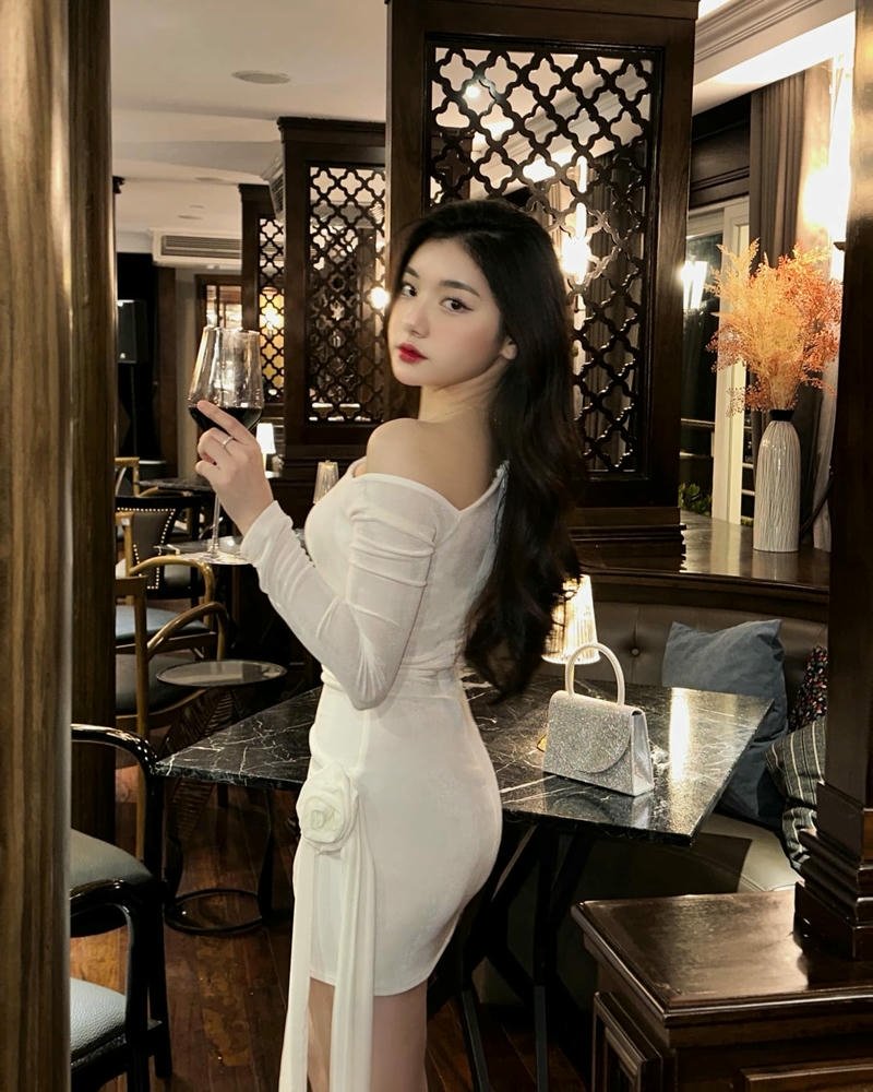 Ảnh Quỳnh Trương Tiktok mặc váy trắng ngồi quán cà phê