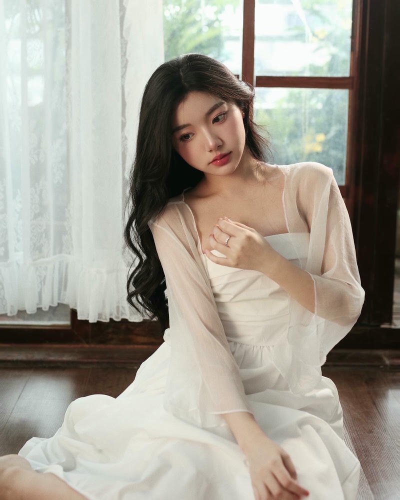 Ảnh Quỳnh Trương Tiktok mặc váy trắng ngồi tạo dáng đẹp