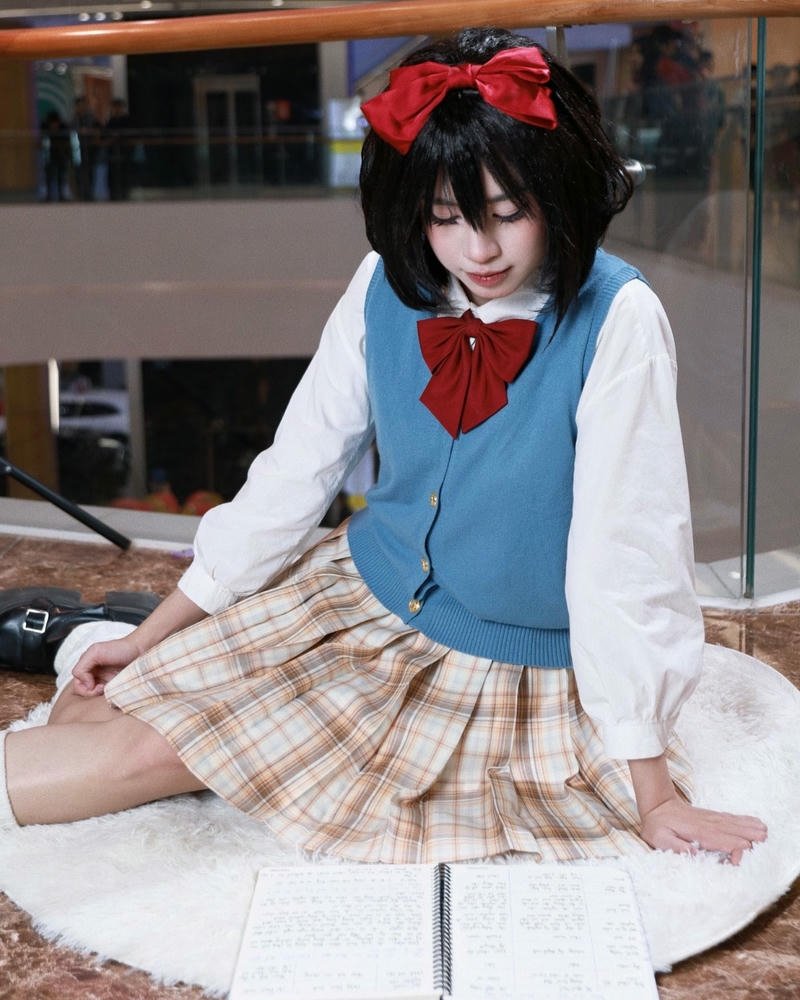 Ảnh cosplay anime nữ sinh váy ngắn ngồi trên sàn nhà gỗ