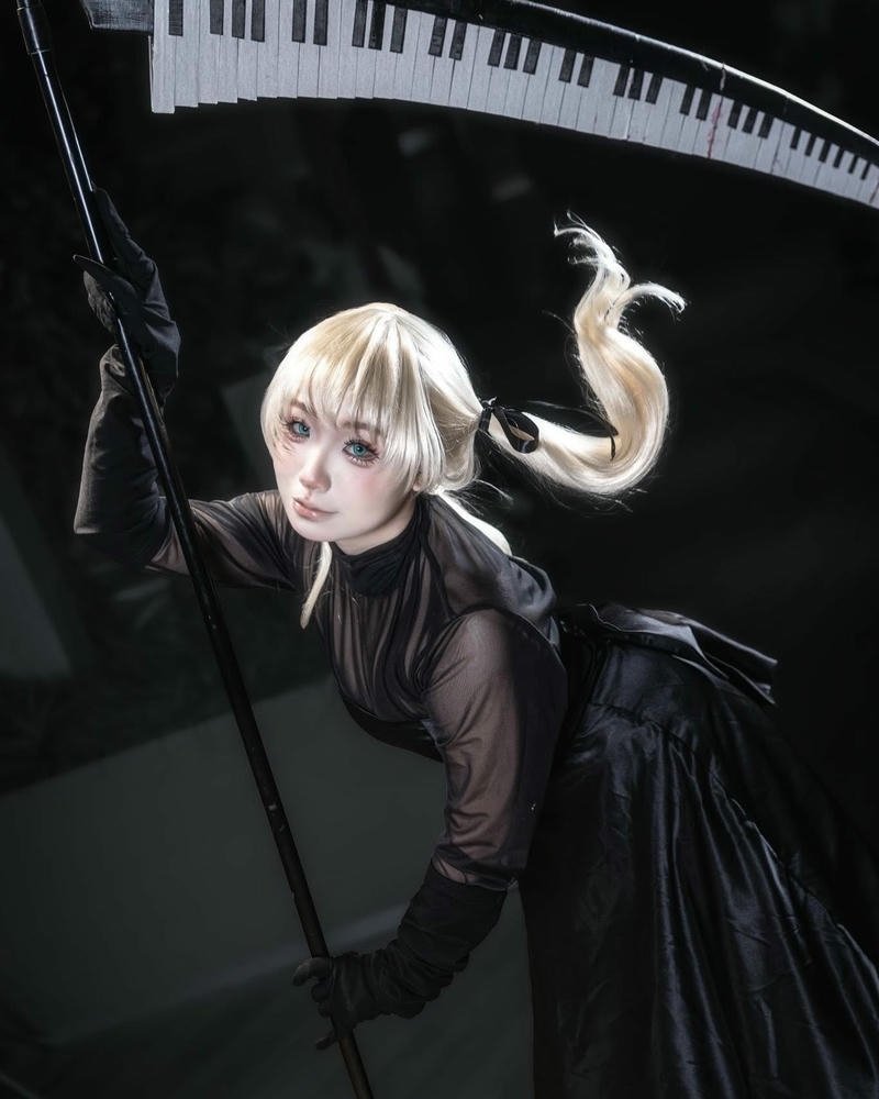Ảnh cosplay nữ tóc vàng cầm lưỡi hái đen bí ẩn