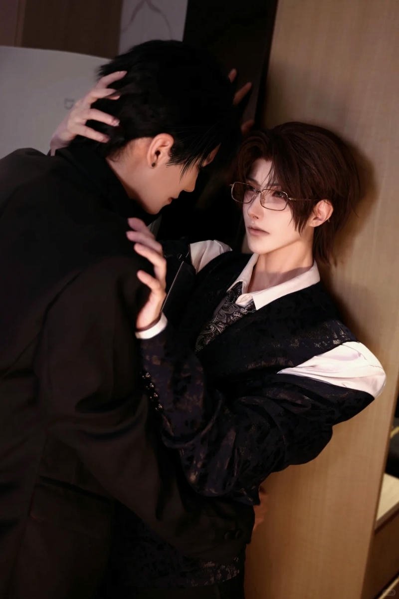 Cosplay đam mỹ hai chàng trai mặc vest đen ôm nhau chặt