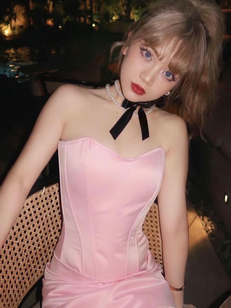 Helia xinh đẹp mặc váy hồng cúp ngực ngồi ghế mây tre