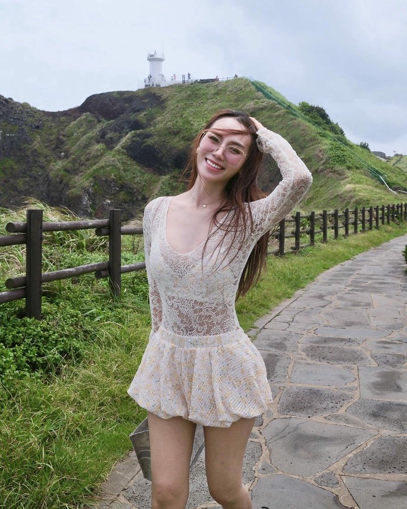 Hoàng Kim Chi váy ngắn ren trắng đứng giữa thiên nhiên xanh