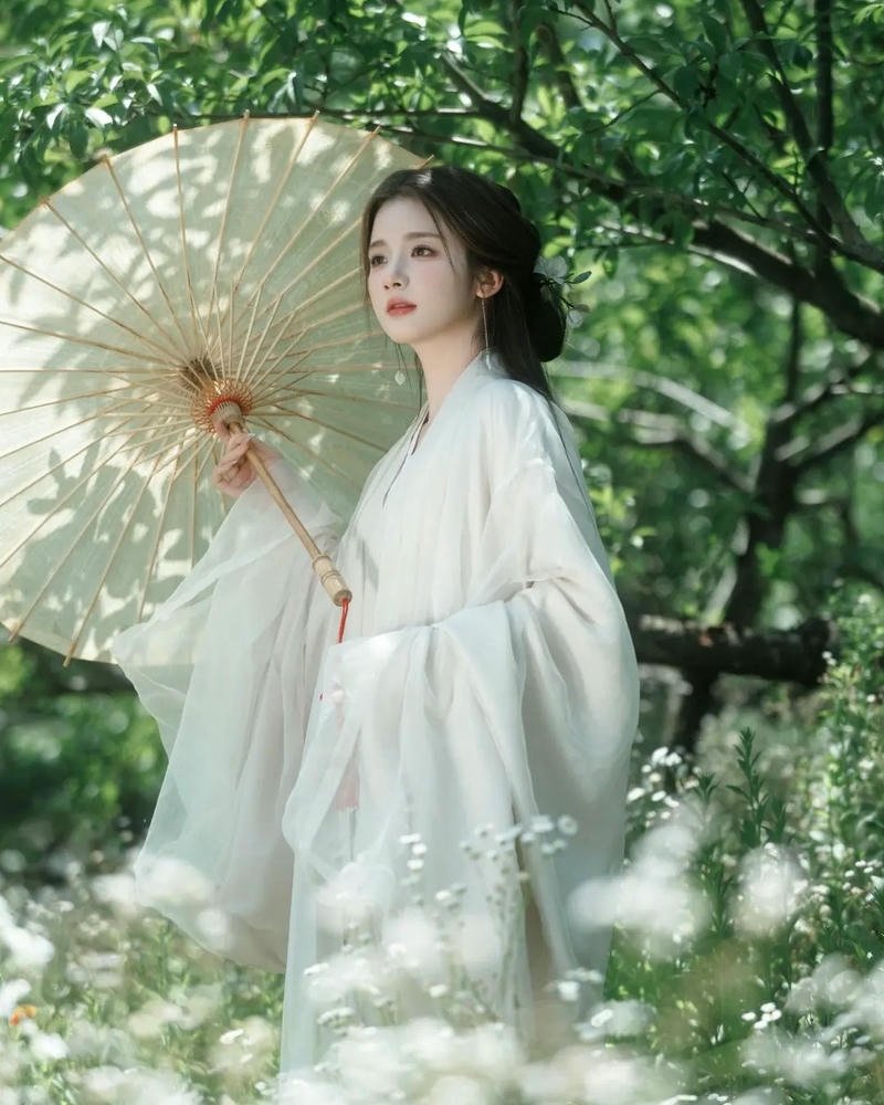 Mỹ nhân cổ trang mặc váy trắng cầm ô dưới tán cây