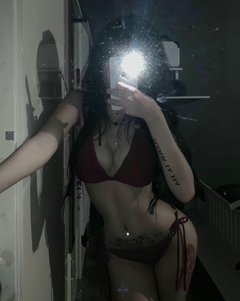 Người đẹp mặc bikini nhỏ ngồi trên giường trắng