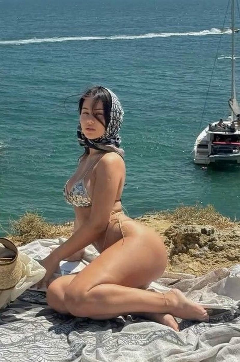 Người mẫu tây bikini xám tạo dáng bên bờ biển