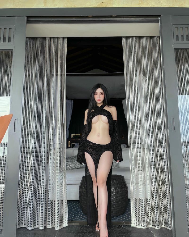 Phạm Hồng Nhung mặc bikini đen đứng giữa rèm cửa trắng