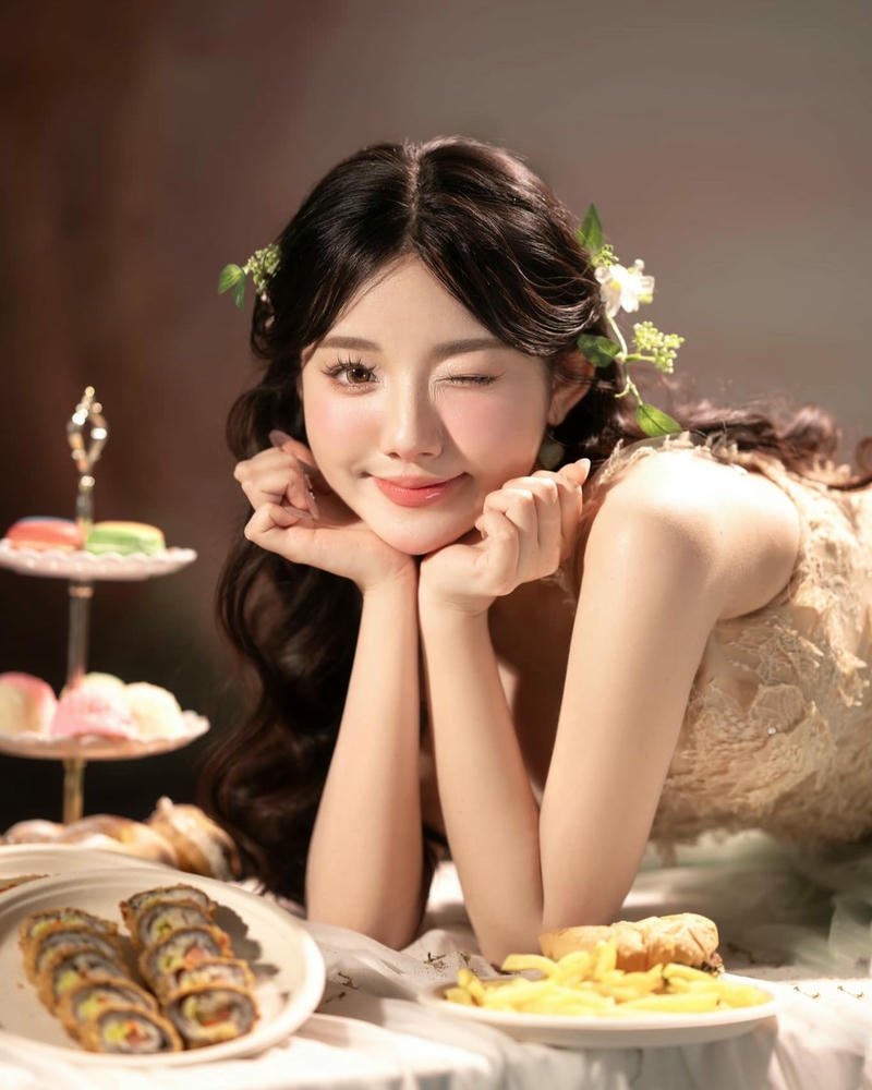 Quỳnh Trương đáng yêu chống cằm ngồi bên bàn tiệc ngọt