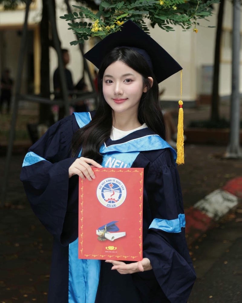 Quỳnh Trương tốt nghiệp mặc áo cử nhân cầm bằng cười