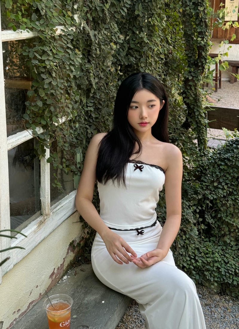 Quỳnh Trương xinh đẹp mặc váy trắng ngồi ghế đá công viên