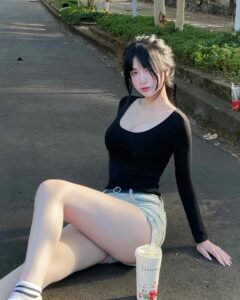 Ảnh gái ngon mặc áo đen quần ngắn ngồi vỉa hè