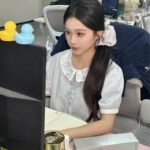 Ảnh gái văn phòng đeo tai nghe ngồi trước màn hình máy tính