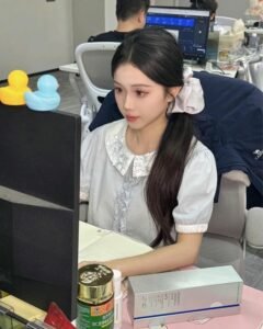 Ảnh gái văn phòng đeo tai nghe ngồi trước màn hình máy tính