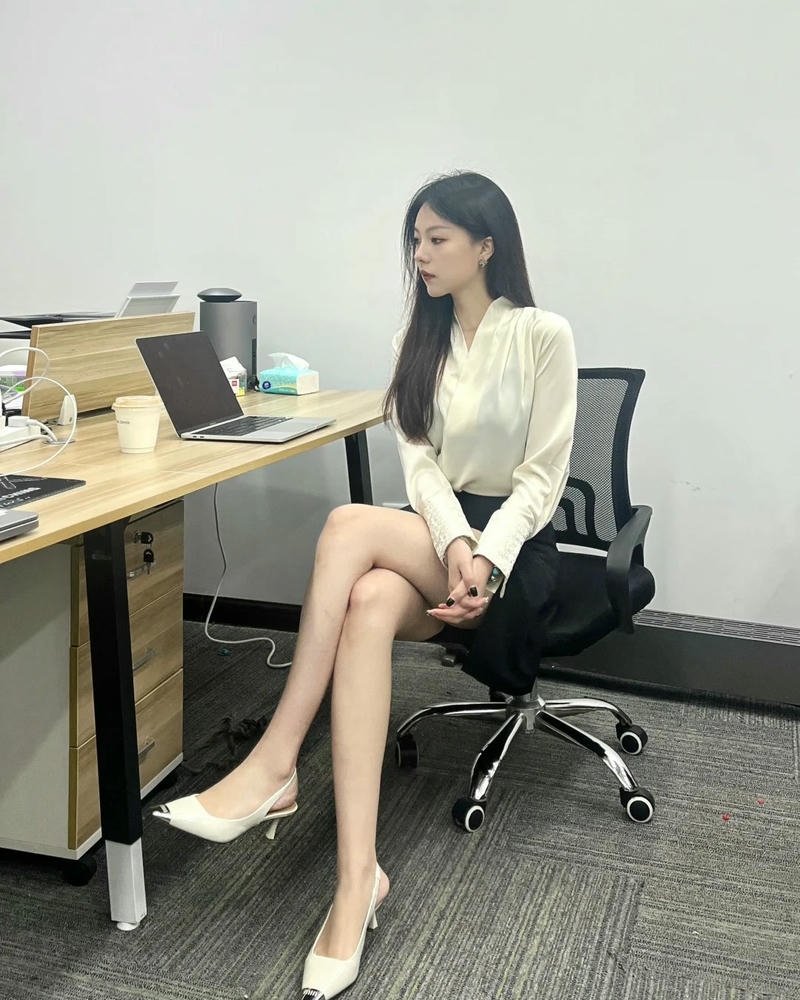 Ảnh gái văn phòng mặc váy ngắn ngồi ghế gác chân thư giãn