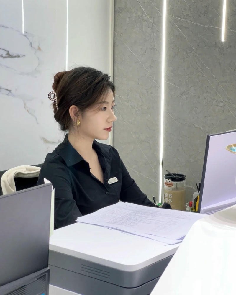 Ảnh gái văn phòng ngồi trước màn hình máy tính văn phòng lớn