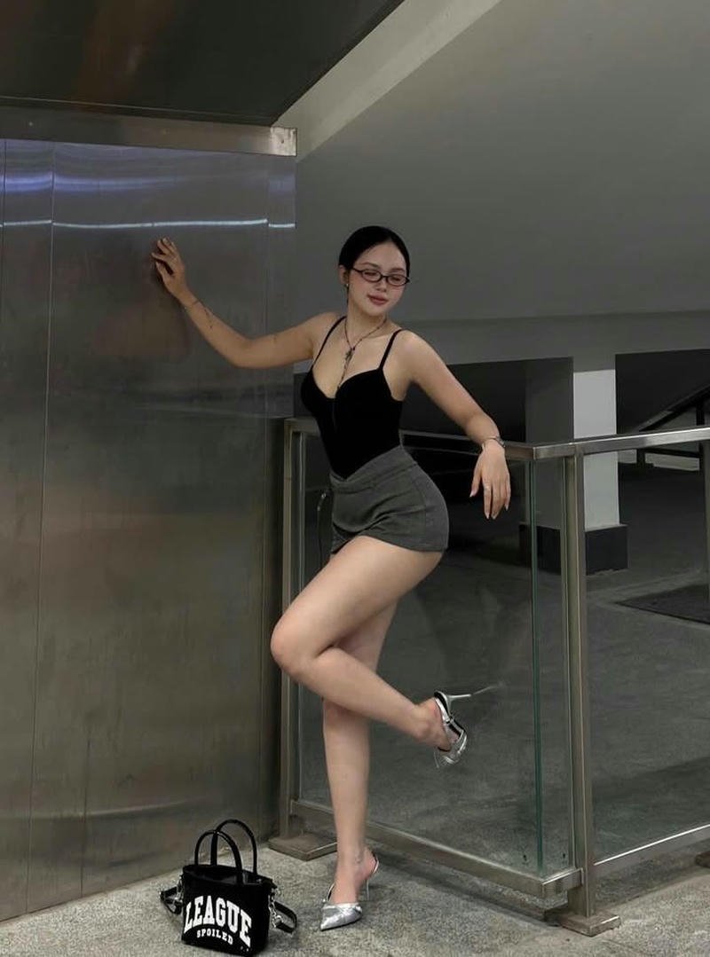 Gái đẹp quyến rũ mặc váy đen đứng trên cầu thang