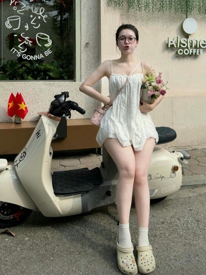 Gái đẹp váy ngắn đứng cạnh chiếc xe máy trắng