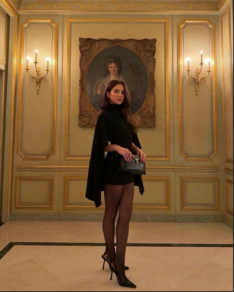 Gái tây váy đen ngắn đứng trong phòng tranh