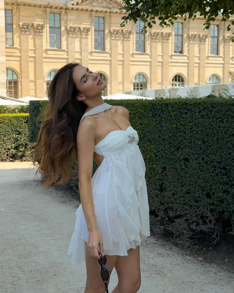 Gái xinh châu âu váy trắng ngắn đứng trong vườn