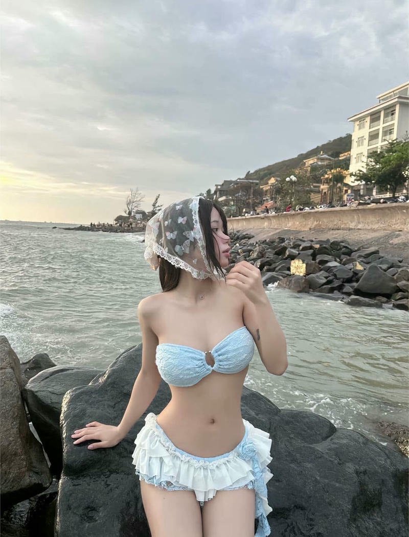 Gái xinh mặc váy ngắn đi biển tạo dáng trên đá