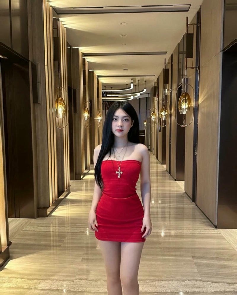 Gái xinh mặc váy ngắn đỏ rực rỡ đứng giữa sảnh