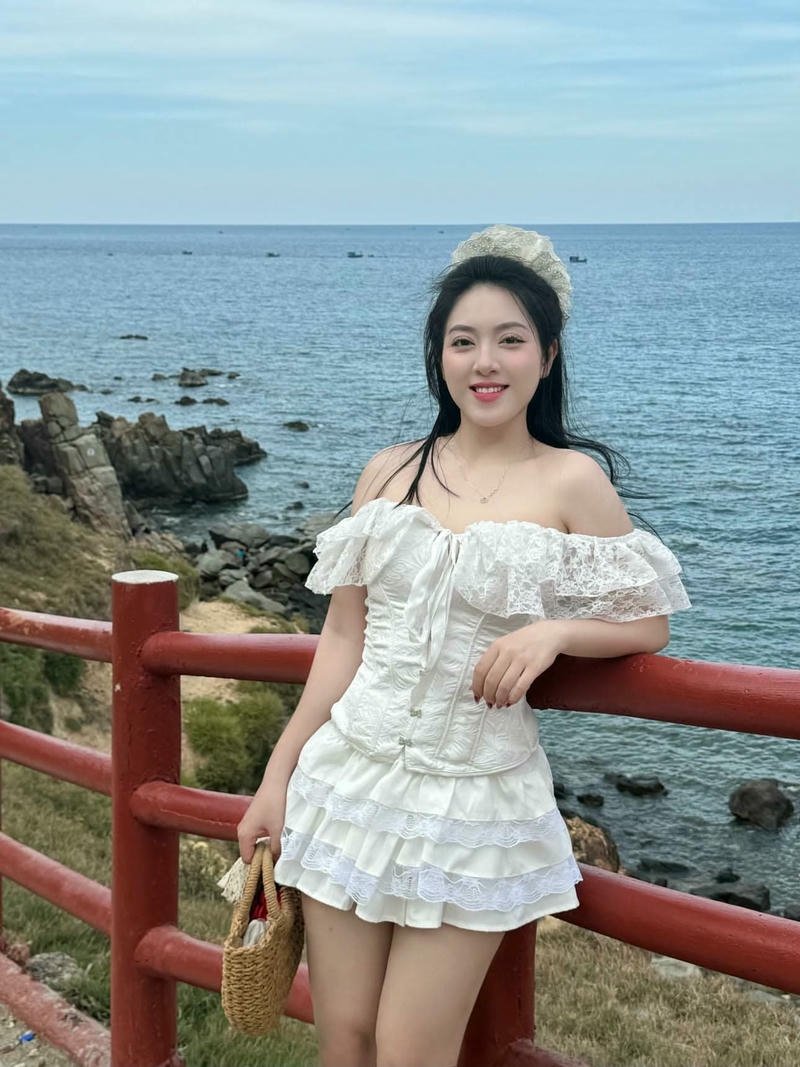 Hot girl váy ngắn màu trắng đứng trước biển xanh