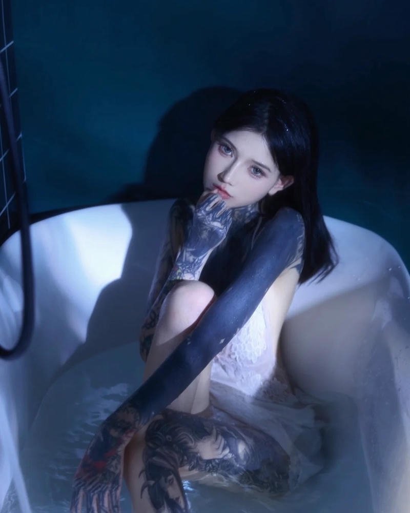 Mỹ nhân tattoo tạo dáng trong bồn tắm ánh sáng xanh