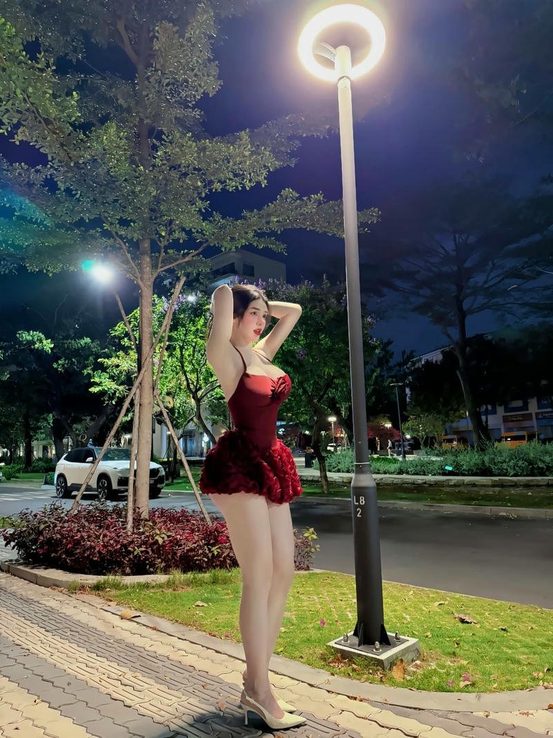Mỹ nhân váy ngắn đỏ đứng dưới ánh đèn đường